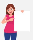 Young beautiful woman smiling and holding a blank / empty sheet of white paper or board and pointing with index finger. Royalty Free Stock Photo