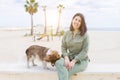 Young beautiful woman smiling very happy by the beach walking dog Royalty Free Stock Photo