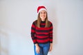 Young beautiful woman smilling happy wearing striped sweater and a santa claus hat at christmas Royalty Free Stock Photo