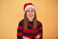 Young beautiful woman smilling happy wearing striped sweater and a santa claus hat at christmas over yellow background Royalty Free Stock Photo
