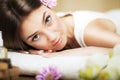 Portrait of a beautiful girl in a spa. Gentle look. Flowers in hair. Aroma oil. Massage cabinet. The concept of health and beauty. Royalty Free Stock Photo