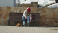 Young beautiful woman in sporty warm clothes and rollers, sitting on a wooden bench and dresses roller skates getting Royalty Free Stock Photo