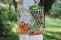 Young beautiful woman standing with ecological zero waste shopping bag with vegetables Royalty Free Stock Photo