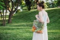 Young beautiful woman standing with ecological zero waste shopping bag with vegetables Royalty Free Stock Photo