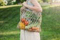 Young beautiful woman standing with ecological zero waste shopping bag with vegetables Royalty Free Stock Photo