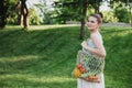 Young beautiful woman standing with ecological zero waste shopping bag with vegetables Royalty Free Stock Photo