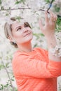 Young beautiful woman standing near blooming white cherry tree Royalty Free Stock Photo