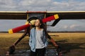 Young beautiful woman standing near the plane. Traveling and technology