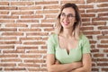 Young beautiful woman standing over bricks wall smiling looking to the side and staring away thinking Royalty Free Stock Photo