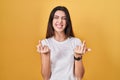 Young beautiful woman standing over yellow background showing middle finger doing fuck you bad expression, provocation and rude Royalty Free Stock Photo