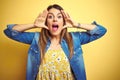 Young beautiful woman standing over yellow isolated background Smiling cheerful playing peek a boo with hands showing face Royalty Free Stock Photo