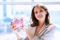 Young beautiful woman standing with piggy bank money box, isolated on white background Royalty Free Stock Photo