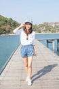 Young beautiful woman standing on wood pier with blue sea water Royalty Free Stock Photo