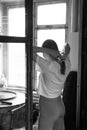 young beautiful woman stands near the window, black and white photo