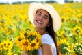 Young beautiful woman in a straw hat and with a bouquet of flowers in a field of sunflowers Royalty Free Stock Photo