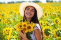 Young beautiful woman in a straw hat and with a bouquet of flowers in a field of sunflowers Royalty Free Stock Photo