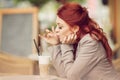 Young beautiful woman in a street cafe enjoying a coffee, summerly urban mood