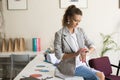 Young beautiful woman in striped jacket sitting on desk thoughtf