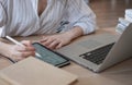 Young beautiful woman student with digital tablet and laptop studying working at home at the table Royalty Free Stock Photo