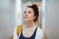 Young beautiful woman student with pencils in hair bun, standing in hall of college university Royalty Free Stock Photo