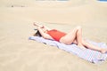 Young beautiful woman sunbathing lying on towel and wearing summer swinsuit at maspalomas dunes bech Royalty Free Stock Photo
