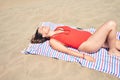 Young beautiful woman sunbathing lying on towel and wearing summer swinsuit at maspalomas dunes bech Royalty Free Stock Photo