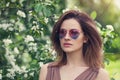 Young beautiful woman in sunglasses outdoors. Cute girl with brown layered hair, spring portrait Royalty Free Stock Photo