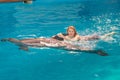 Young beautiful woman swimming with dolpin in a dolfinarium