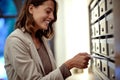 A young and beautiful woman is taking a mail from the post box in the building entrance. Mail, building, home Royalty Free Stock Photo