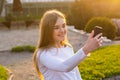 A young beautiful woman taking selfie in a park at sunset Royalty Free Stock Photo