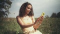 Young beautiful woman taking selfie on phone while sitting on grass.