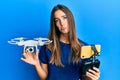 Young beautiful woman taking a selfie photo with smartphone flying drone depressed and worry for distress, crying angry and afraid Royalty Free Stock Photo