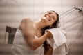 Young beautiful woman after taking a shower standing in the bathroom wipes her hair with a white towel Royalty Free Stock Photo