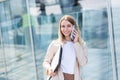 Young beautiful woman talking on a cell phone near the office, a businesswoman on a lunch break Royalty Free Stock Photo