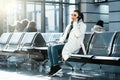 Young beautiful woman talking by mobile phone in modern light airport. Royalty Free Stock Photo