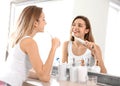 Young beautiful woman with toothbrush near mirror in bathroom Royalty Free Stock Photo