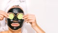 Woman applying black charcoal facial mask. Face skin care.Spa therapy.Copy space Royalty Free Stock Photo