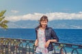 Young beautiful woman traveler looking camera, smile and posing on embankment Lungomare Falcomata in Reggio Calabria Royalty Free Stock Photo