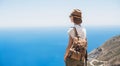 Young woman traveler looking at the sea. Beautiful girl enjoying nature. Summer holidays, vacations, travel, tourism concept