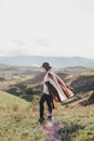 Young beautiful woman traveler wearing hat and poncho relaxing on the top of the hill Royalty Free Stock Photo