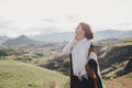 Young beautiful woman traveler wearing hat and poncho relaxing on the top of the hill Royalty Free Stock Photo