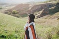 Young beautiful woman traveler wearing hat and poncho relaxing on the top of the hill Royalty Free Stock Photo