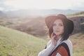 Young beautiful woman traveler wearing hat and poncho relaxing on the top of the hill Royalty Free Stock Photo