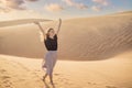 Young beautiful woman traveling in the desert. Sandy dunes and blue sky on sunny summer day. Travel, adventure, freedom Royalty Free Stock Photo