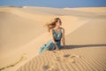 Young beautiful woman traveling in the desert. Sandy dunes and blue sky on sunny summer day. Travel, adventure, freedom Royalty Free Stock Photo