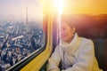 Young beautiful woman traveling looking view Eiffel in sunset while sitting in the train at paris, France