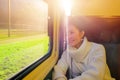 Young beautiful woman traveling looking view while sitting in the train