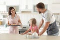 Young beautiful woman treating her family with freshly oven baked buns