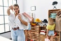 Young beautiful woman with two daughters holding shopping bags at retail shop with angry face, negative sign showing dislike with Royalty Free Stock Photo