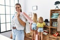 Young beautiful woman with two daughters holding shopping bags at retail shop looking positive and happy standing and smiling with Royalty Free Stock Photo